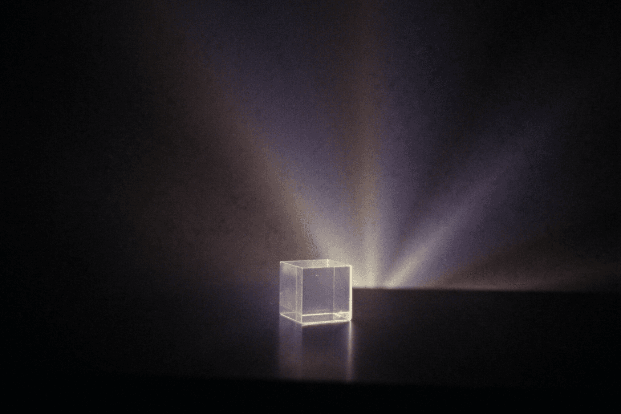 A glowing prism casting rays of light across the dark.